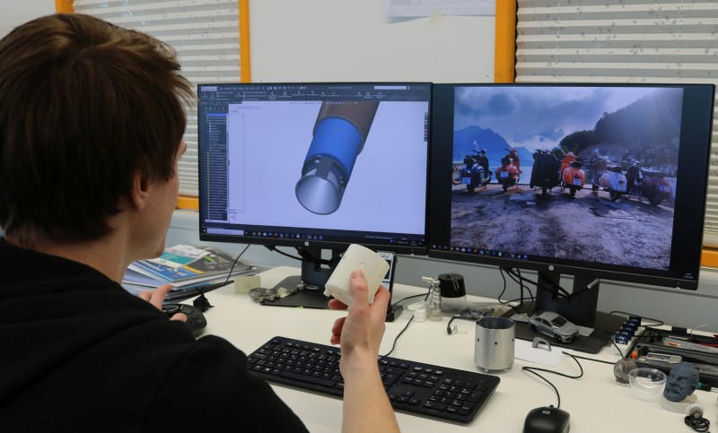 Konstrukteur Martin Odermatt am CAD und mit dem gedruckten Teil.